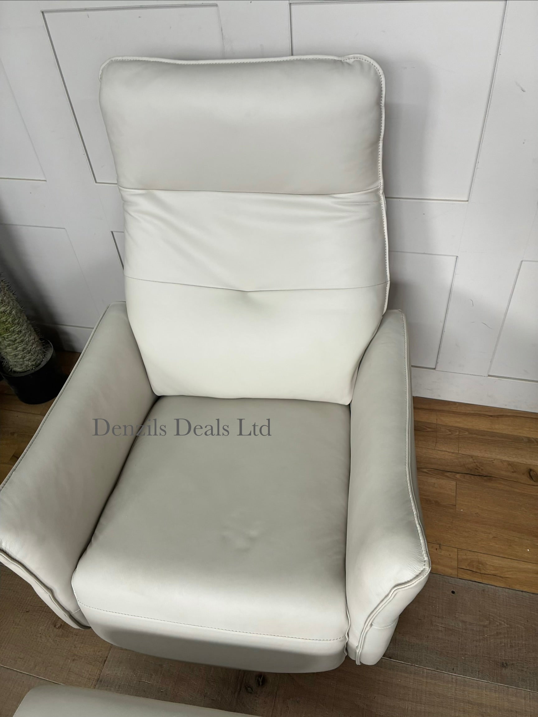Minimalist modern interior scene featuring a John Lewis Relaxed premium leather recliner chair and footstool. The sleek, tan-coloured leather upholstery contrasts with thin metal legs, offering a refined look for a modern living space.
