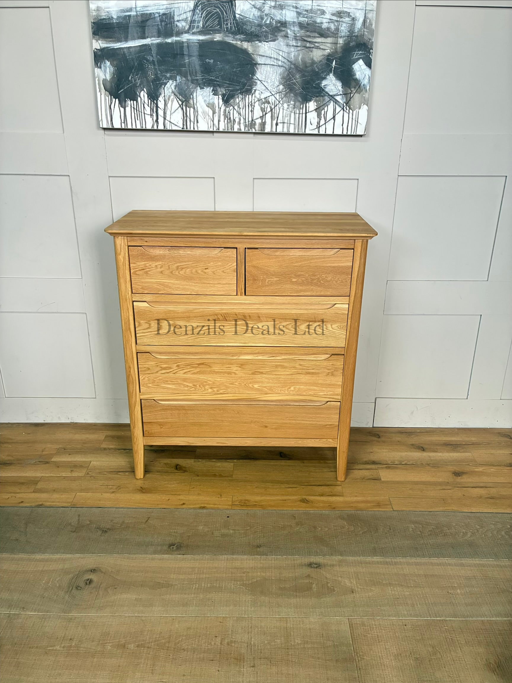 A front view of a contemporary mid-century style 2+3 chest of drawers made from light natural solid oak, featuring rounded corners, tapered legs, and flat-fronted drawers with clean recessed groove handles