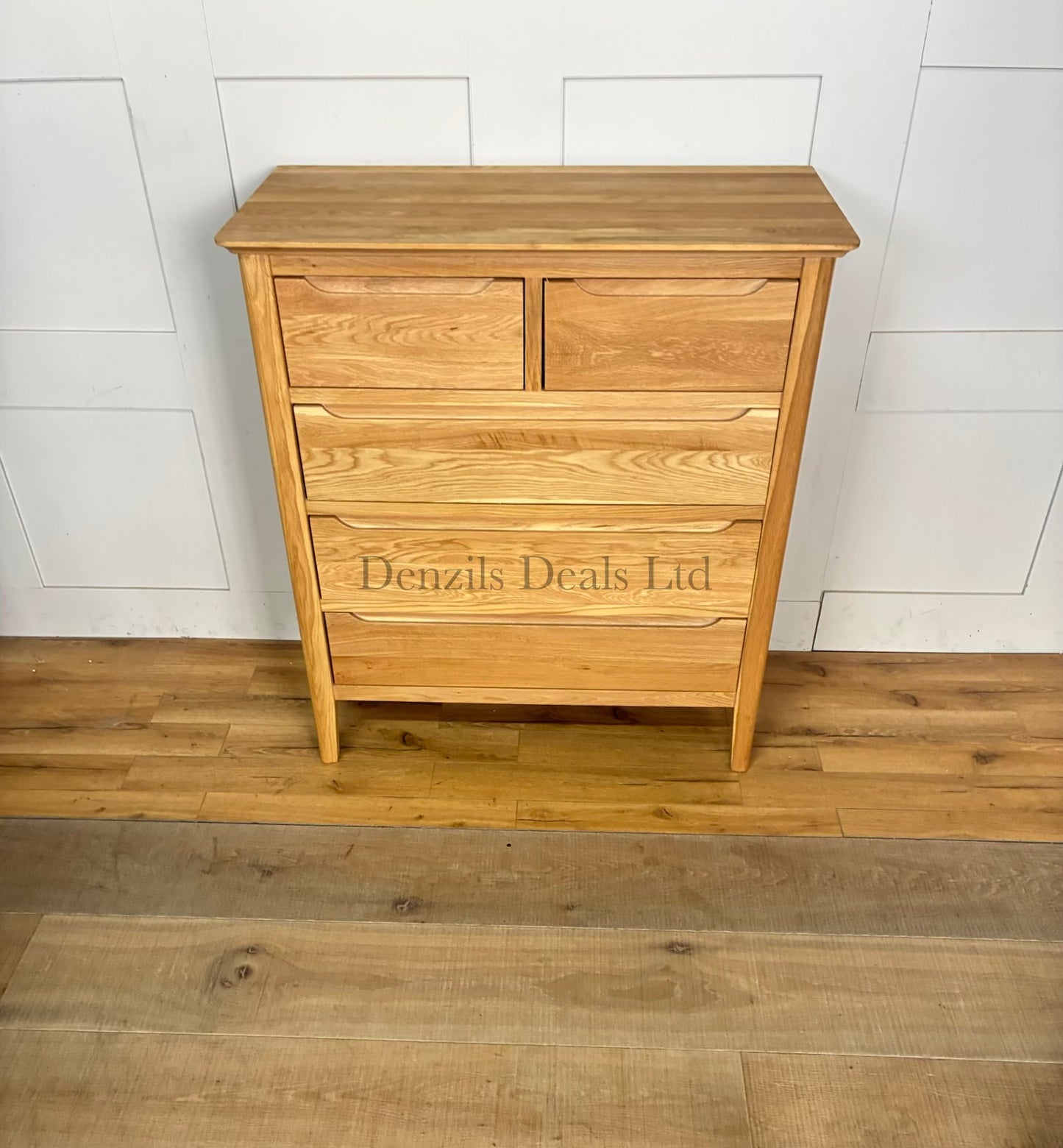 A front view of a contemporary mid-century style 2+3 chest of drawers made from light natural solid oak, featuring rounded corners, tapered legs, and flat-fronted drawers with clean recessed groove handles