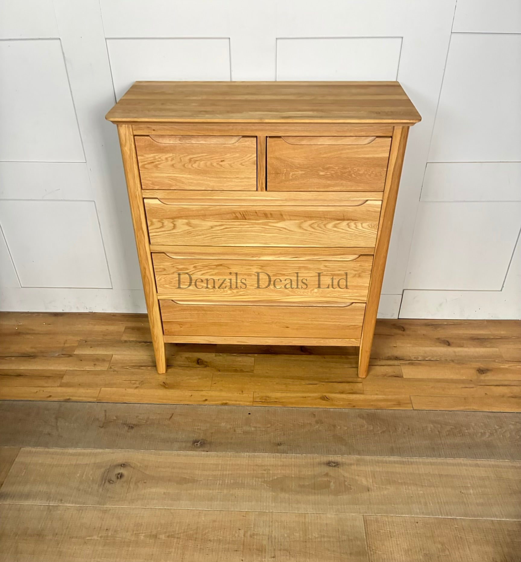 A front view of a contemporary mid-century style 2+3 chest of drawers made from light natural solid oak, featuring rounded corners, tapered legs, and flat-fronted drawers with clean recessed groove handles