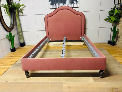an upholstered divan-style bed featuring elegant double-piped edging around the headboard and footboard for a tailored, hand-worked look with complete slats