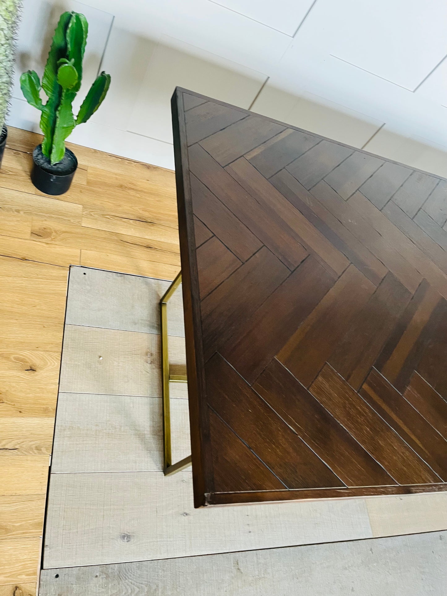A vintage-inspired, dark wood herringbone dining table from Dutchbone set in a warmly lit