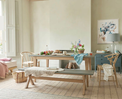  extra large Loaf Budge dining benches with grey tops and wooden legs paired with a matching kitchen dining table in a bright, modern room.