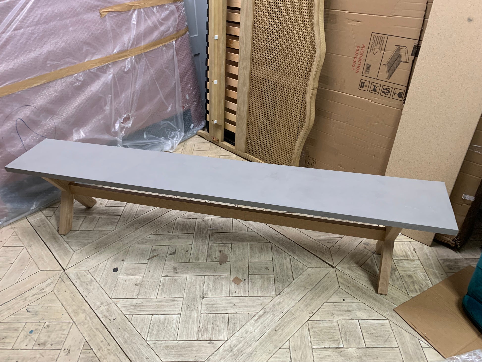  extra large Loaf Budge dining benches with grey tops and wooden legs paired with a matching kitchen dining table in a bright, modern room.