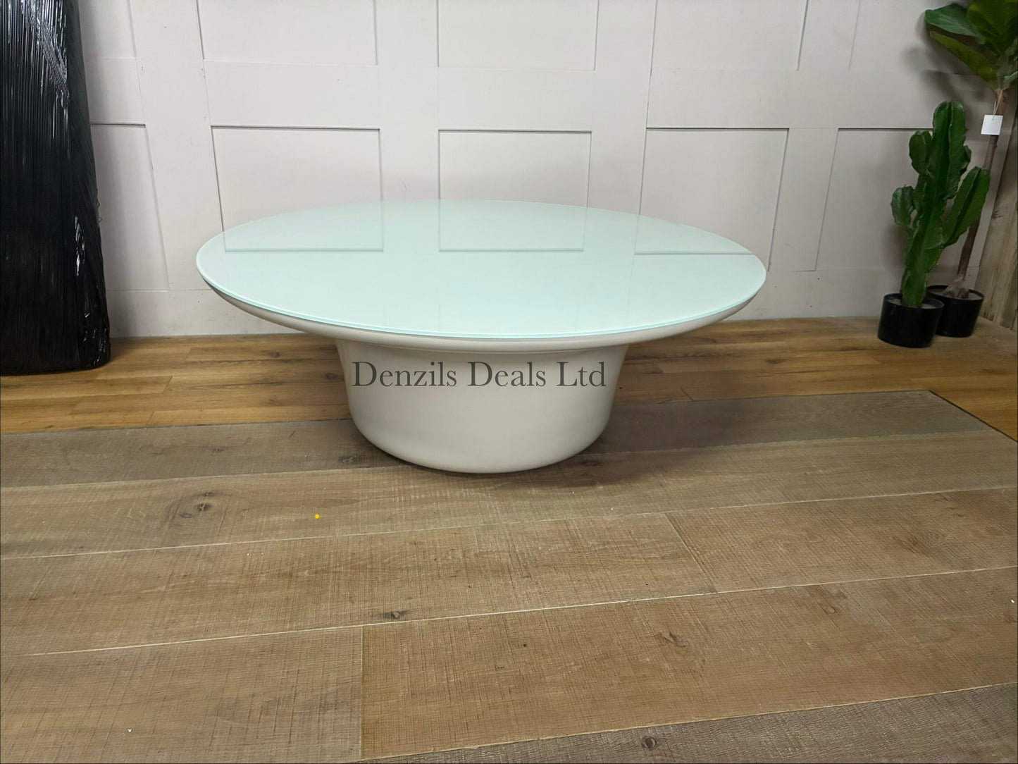 Low-profile, round indoor/outdoor Dulce 42” Round coffee table featuring a smooth, light-coloured concrete body and a thin inset glass top.