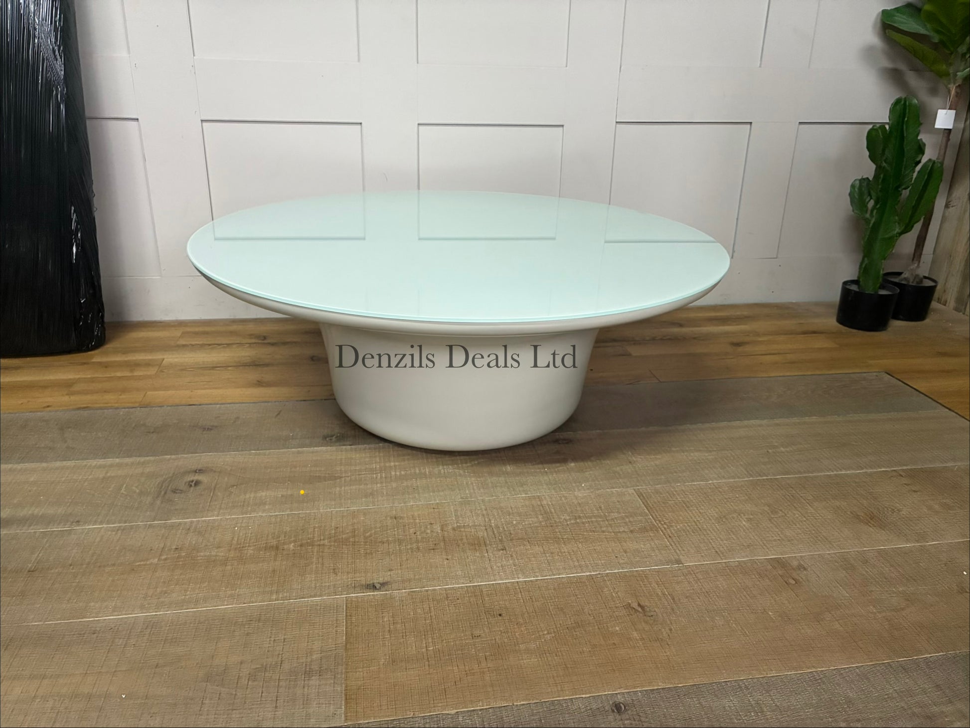 Low-profile, round indoor/outdoor Dulce 42” Round coffee table featuring a smooth, light-coloured concrete body and a thin inset glass top.