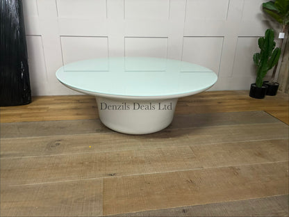 Low-profile, round indoor/outdoor Dulce 42” Round coffee table featuring a smooth, light-coloured concrete body and a thin inset glass top.