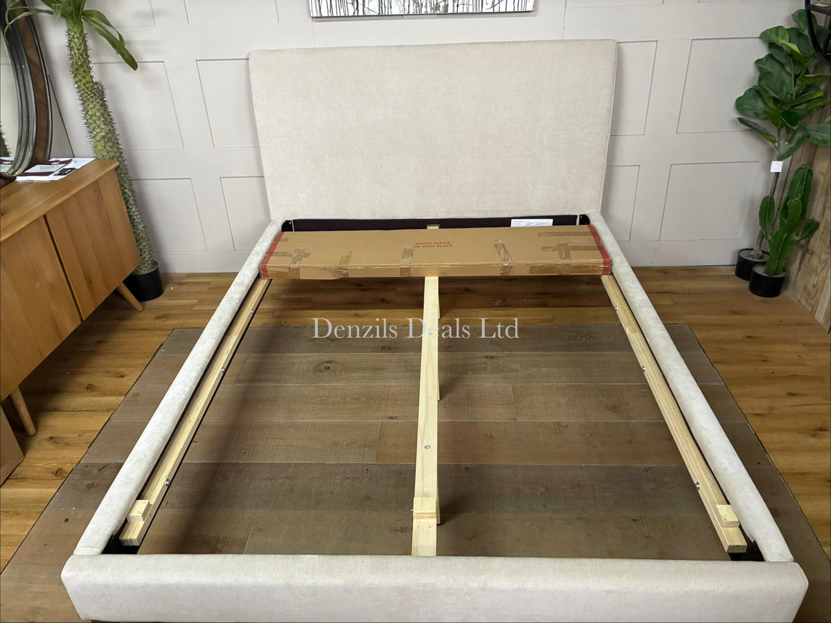 modern, customisable upholstered bed frame featuring a plush, clean-lined headboard and tall cast metal legs.