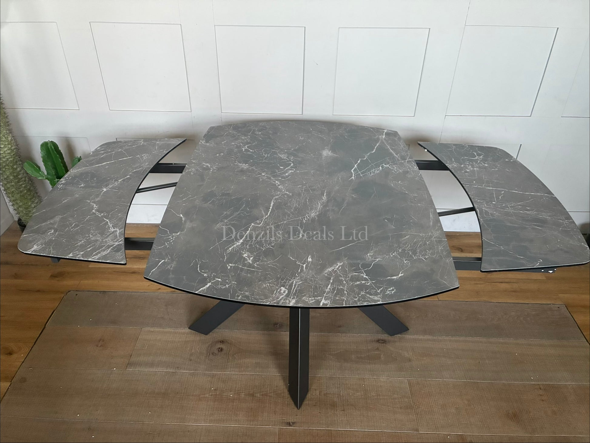 A modern rectangular extending dining table featuring a sleek printed glass top with an HPL finish and a smooth twist-to-open central extension mechanism, supported by a contemporary matte metal base."