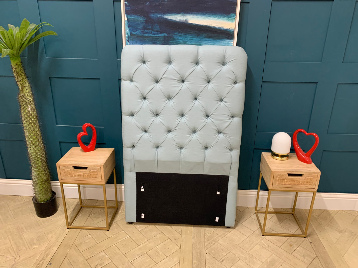 Upholstered single headboard in a pale, dusty blue featuring Loaf's signature pillowy cushion design and a tall profile. 