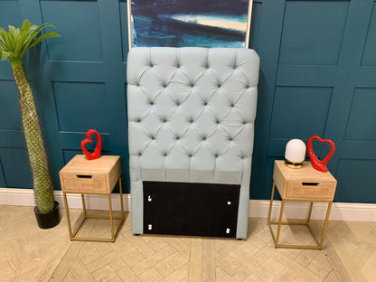 Upholstered single headboard in a pale, dusty blue featuring Loaf's signature pillowy cushion design and a tall profile. 
