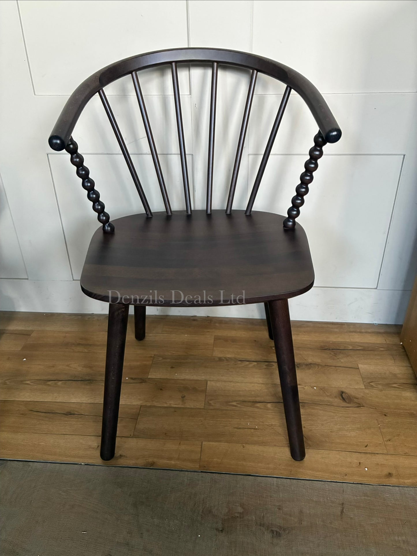 Close-up of the Anthropologie Bobbin Spindle Chair, emphasizing the intricate, hand-carved turned-wood craftsmanship and light wood texture."