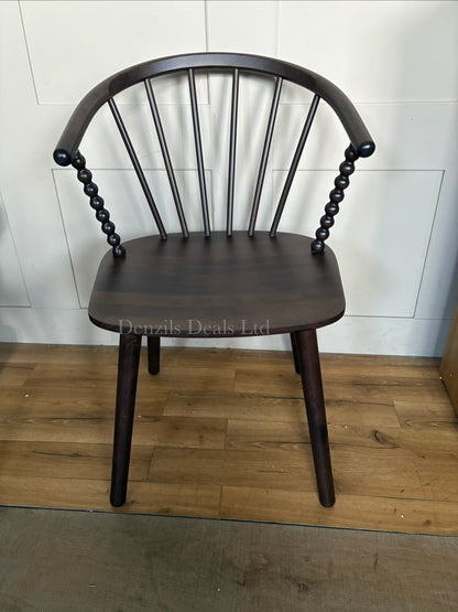 Close-up of the Anthropologie Bobbin Spindle Chair, emphasizing the intricate, hand-carved turned-wood craftsmanship and light wood texture."