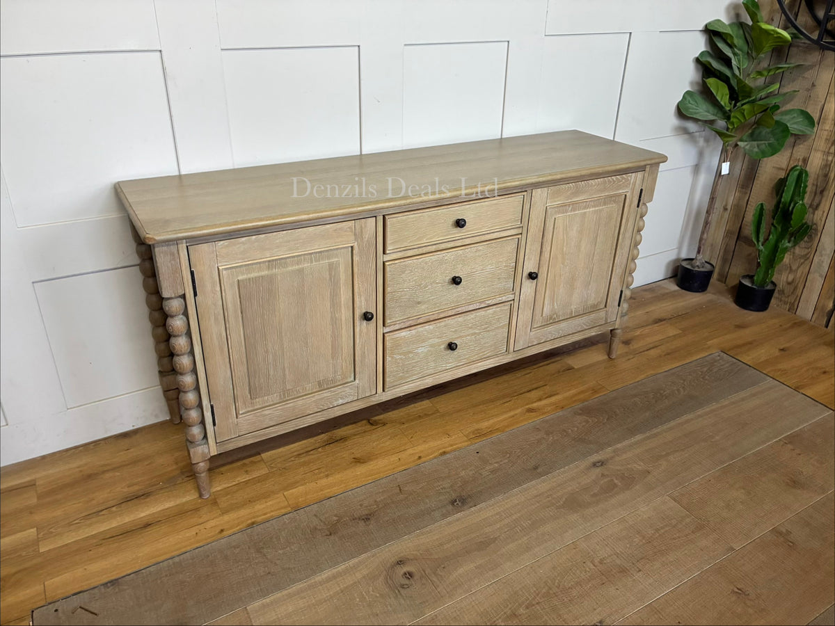 A beautifully crafted light oak furniture piece, the Gallery Direct Bessemer Sideboard, styled in a contemporary living space with its soft, mellow lime wash finish catching the natural room light