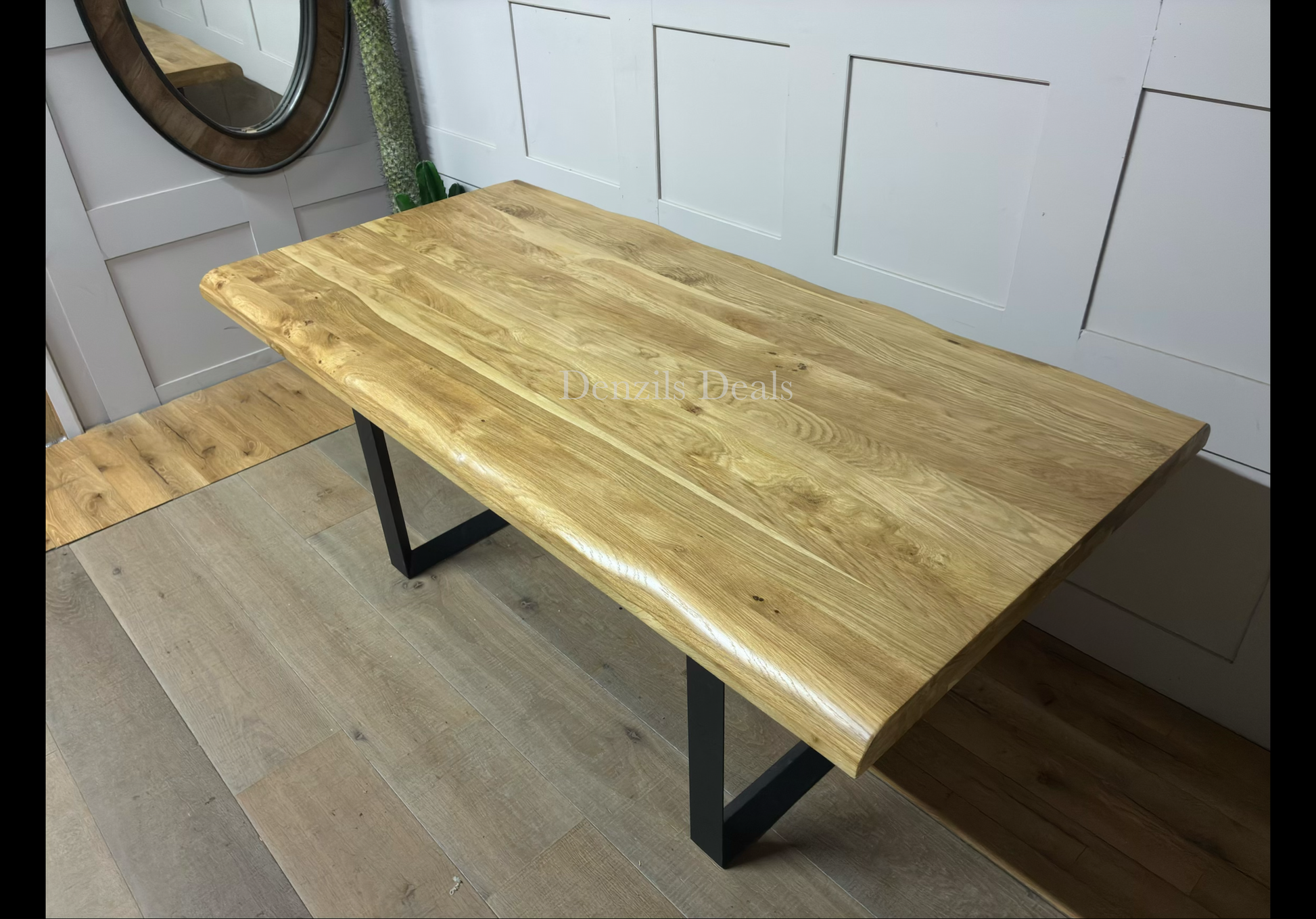 Modern industrial dining room setting featuring the Oak Furnitureland Brooklyn 8-seater dining table. The table showcases a solid natural oak tabletop with distinctive wood grain patterns and curved, wavy live edges, supported by dark, industrial-style metal legs