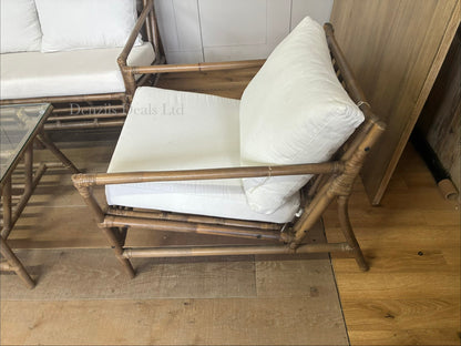Brown bamboo sofa set with two armchairs and a glass-topped coffee table.