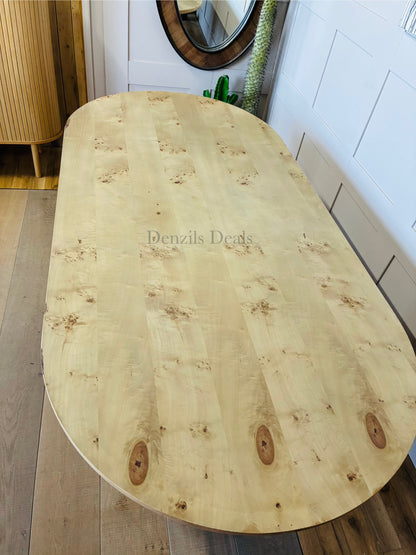 Interior shot of the Anthropologie Scout dining table, crafted from blond ash wood with an organic woodgrain veneer top and whimsical, curved fluted legs